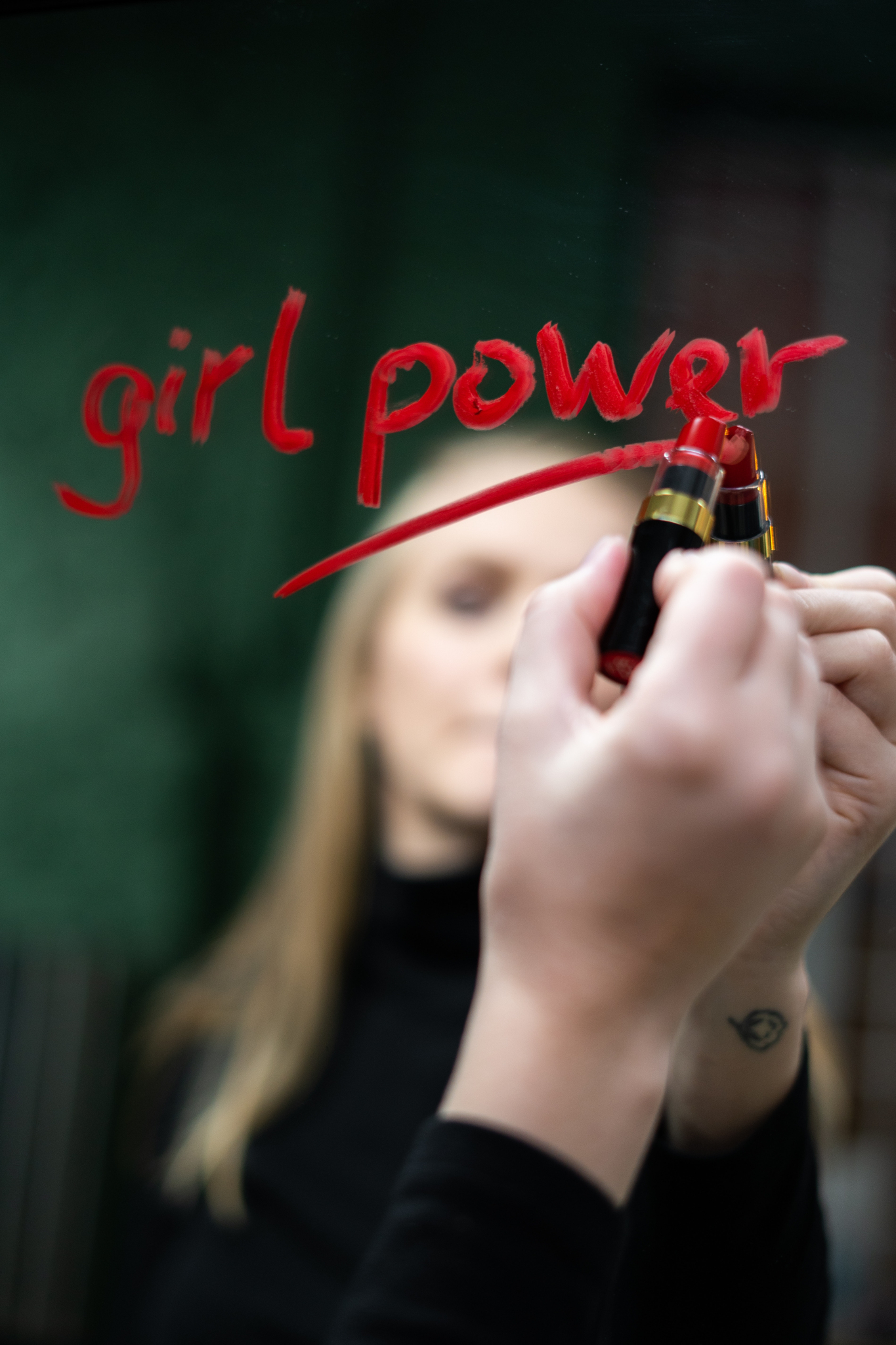 Mujer delante de un espejo que ha escrito su lema, "Girl power"