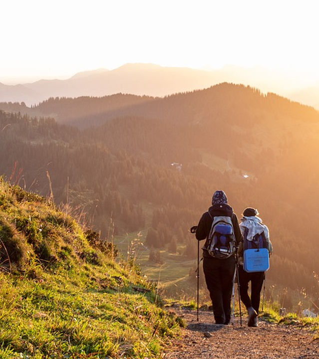 dos personas caminando por la montaña